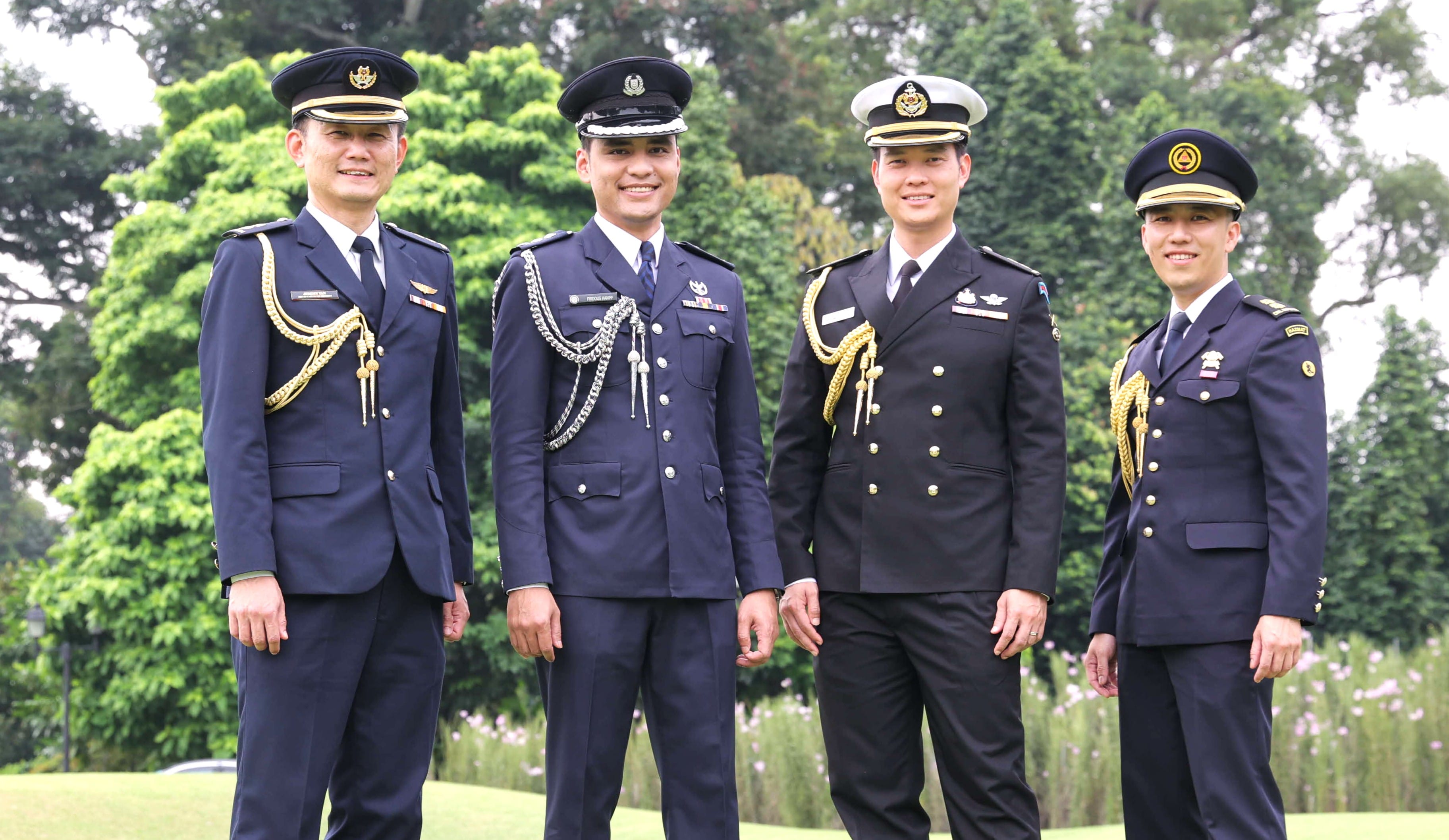 Four men in military uniforms with gold/silver trim and hats.